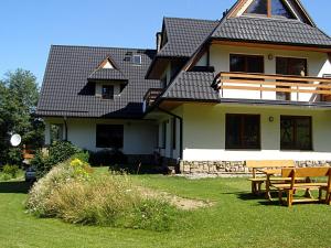 a house with a table and a bench in the yard at Dom Gościnny Na Skolach in Gliczarów