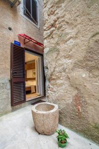 a stone building with a planter in front of a building at Apartments Calma in Cres