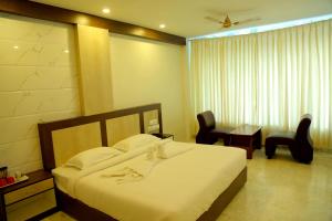 A bed or beds in a room at Sri Maharaja Residency