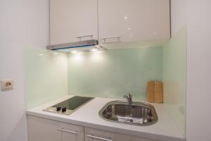 a kitchen with a sink and a mirror above it at Apartments Calma in Cres +27 photos