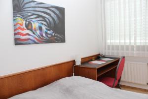 ein Schlafzimmer mit einem Schreibtisch und einem Wandgemälde in der Unterkunft Hotel nord in Braunschweig