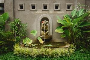 a statue of a lion in a fountain in a garden at Taman Amartha Villa Ubud in Ubud