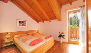 a bedroom with two beds and a large window at Ferienwohnung Walderhof Natz in Natz-Schabs