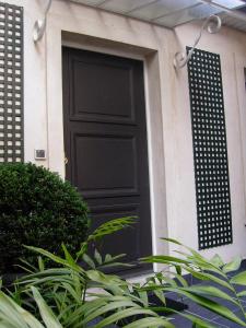 a black door on the side of a house at Hotel De La Jatte in Neuilly-sur-Seine
