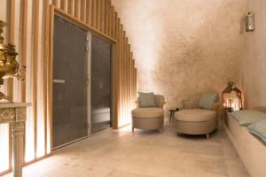 a hallway with two chairs and a door at Château de Fonscolombe - Relais & Châteaux in Le Puy-Sainte-Réparade