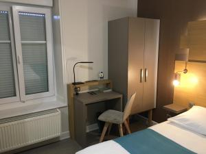 a bedroom with a desk and a bed and a chair at Hotel Du Pont in La GrandʼCombe-Châteleu