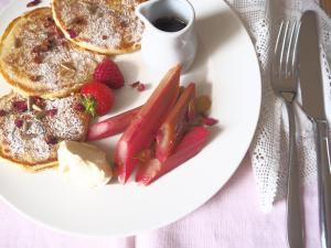 a plate of pancakes and strawberries and a cup of coffee at Dorset House in Lyme Regis