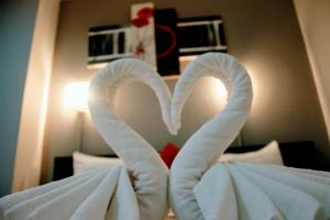 a bed with two swans made out of towels at Holiday Home Patong in Patong Beach