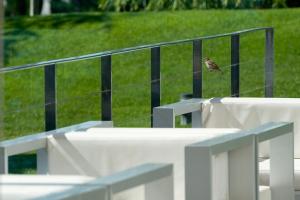 a small bird perched on a rail next to a fence at Finca Prats Hotel Golf & Spa in Lleida