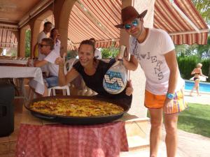dos personas de pie junto a una pizza en una mesa en Casa Los jardines de Lola, en Daimés