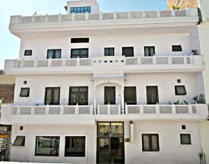 a white building with a balcony at Satkar Hotel in Jaipur