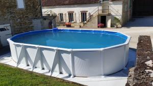 a large swimming pool in a yard with a house at la ferme au ROY in Bernouil