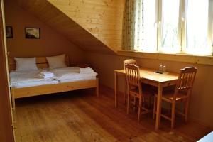 a bedroom with a bed and a table and a bed at Penzion Mlýn Sedlec in Sedlec