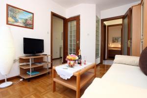 Una sala de estar con un sofá y un televisor. en Lovely Sea View Apartments BJ, en Portorož