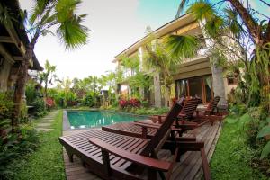 - un groupe de chaises assises à côté de la piscine dans l'établissement Cahyatika Bed & Breakfast, à Ubud