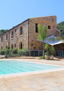 a building with a swimming pool in front of a building at Turismo Rurale Cefalù in Cefalù