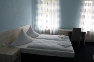 a white bed in a room with a window at Hotel am Fluss in Heidesee