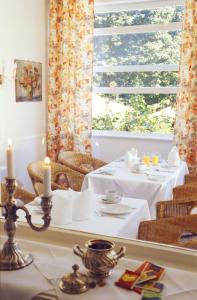 ein Esszimmer mit 2 Tischen und einem Fenster in der Unterkunft Hotel Waldhof auf Herrenland in Mölln