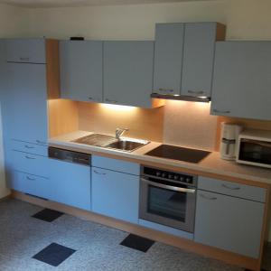 a kitchen with white cabinets and a sink at Ferienwohnung Franck in Kleinarl