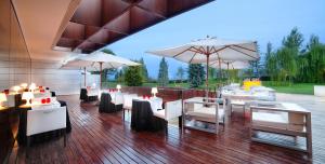 un restaurante con mesas y sombrillas blancas en Finca Prats Hotel Golf & Spa, en Lleida