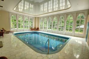 a large swimming pool in a house with windows at Pałac Sulisław in Sulisław