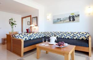 - un salon avec un canapé et une table dans l'établissement Bellamar Hotel Beach & Spa, à Sant Antoni de Portmany