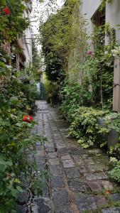 een stenen pad in een tuin met bloemen en planten bij lapetitemaisondeparis in Parijs