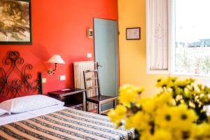sypialnia z pomarańczowymi ścianami i łóżkiem z żółtymi kwiatami w obiekcie Hotel Il Bargellino we Florencji
