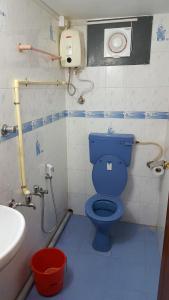 bagno con servizi igienici blu e lavandino di Valiyathayil Home Stay a Cochin Altre 104 foto