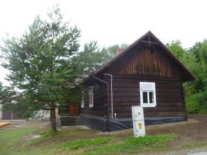 a small wooden house with a tree in front of it at Klimatyczny Domek in Sławęcin