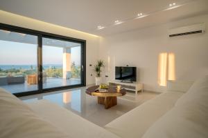 a living room with a white couch and a table at Bianca Luxury Villa - Private Heated Pool in Akrotiri