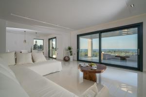 a white living room with a white couch and a table at Bianca Luxury Villa - Private Heated Pool in Akrotiri