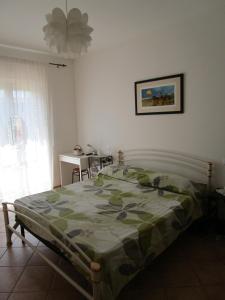 ヌマーナにあるCasa Giulia Poggio del Soleのベッドルーム1室(ベッド1台、緑の掛け布団付)