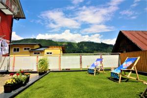 einen Hof mit zwei Stühlen und einem Zaun in der Unterkunft Apartments Luidold in Schladming