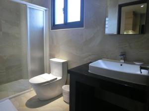 ein Badezimmer mit einem weißen WC und einem Waschbecken in der Unterkunft Happy Hotel in Lukang