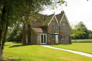 a large brick house with a grass yard at Oakley Hall Hotel in Basingstoke