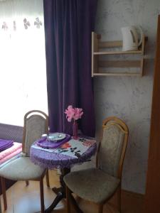 a table with two chairs and a table with a vase of flowers at El Jan Pobierowo in Pobierowo