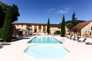 - une piscine dans une cour avec des chaises et un bâtiment dans l'établissement Domaine du Château de Monrecour - Hôtel et Restaurant - Proche Sarlat, à Saint-Vincent-de-Cosse