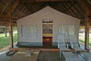 a tent with two chairs and a bed in it at Eden Lodge in Madirokely