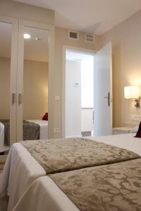 トレモリノスにあるApartamentos Casa Floridoのベッドルーム1室(ベッド1台付)、ベッドルーム1室(ベッド2台付)