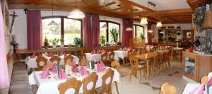 restauracja ze stołami i krzesłami z różowymi serwetkami w obiekcie Hotel-Gasthof Zum Oberen Wirt w mieście Regen