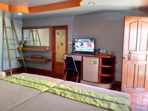 Schlafzimmer mit einem Bett, einem TV und einem Schreibtisch in der Unterkunft Phi Phi Coralbay in Ko Phi Phi