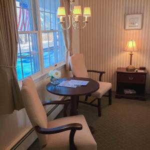 
a living room with a table, chairs and a lamp at Braeside Lodging in Woodstock
