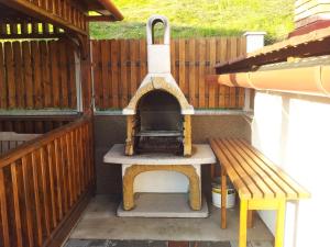 BilborにあるCasa la munteのベンチの横に置かれた屋外ピザ窯