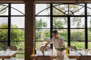 een man aan een tafel in een restaurant bij Relais Sant'Elena in Bibbona