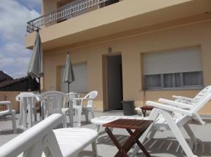 un grupo de sillas y mesas blancas en un patio en O Cabalo Verde, en Palas de Rei 