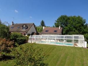 una casa con un invernadero de cristal en un patio en Chambres d'hôtes Legros, en Vierzon