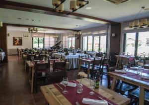 a dining room with tables and chairs and windows at Hostal Cal Batista in Bagá