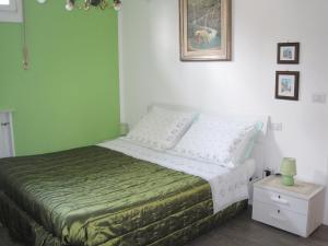 a bedroom with a bed with a green wall at Bed and Breakfast lo Scrigno in Polinago