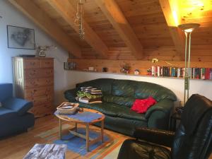 a living room with a green leather couch and a table at Apartment in St. Jakob im Rosental in Sankt Jakob im Rosental